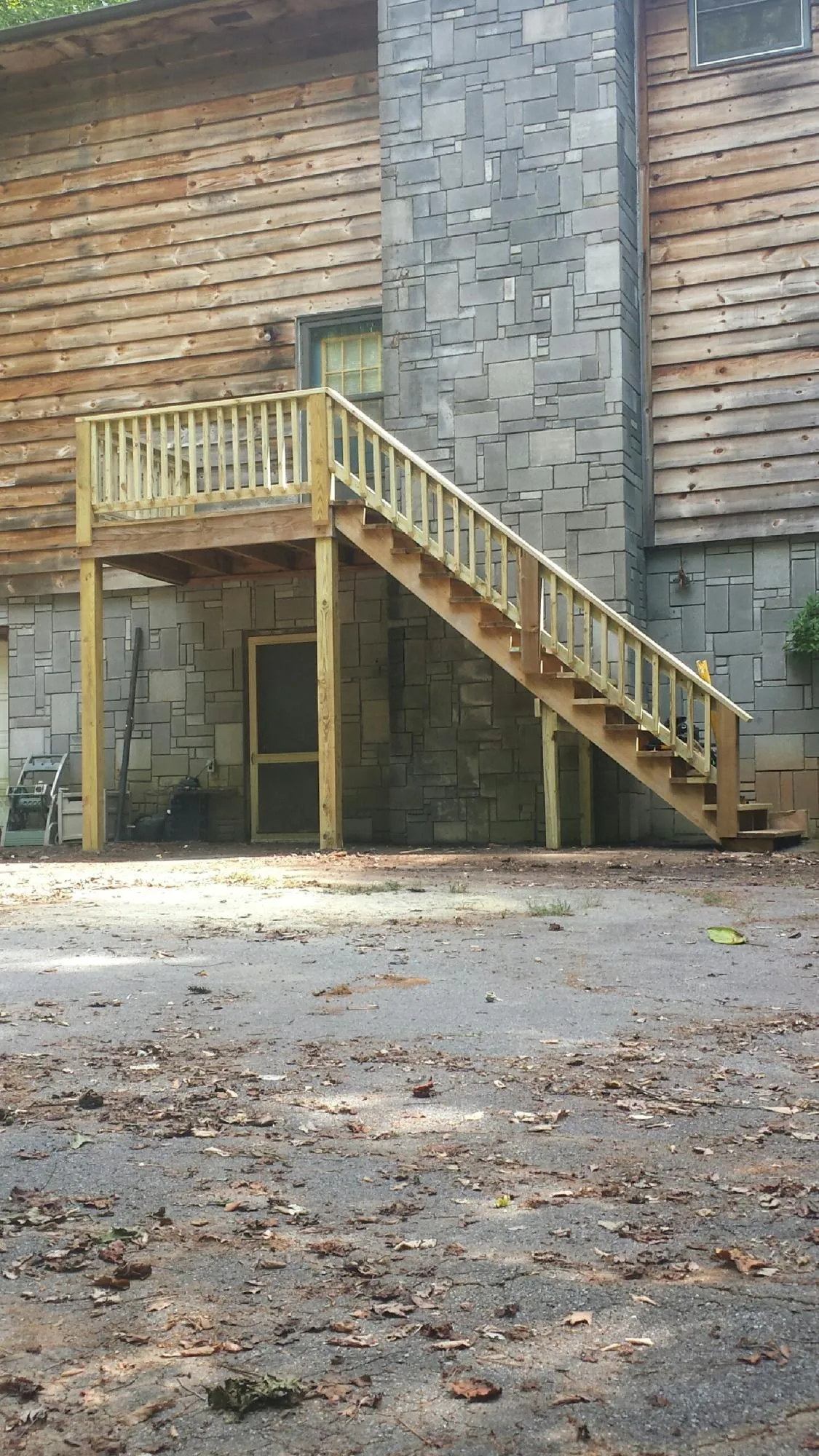 New pressure treated deck and stair landing on a log home in Whitesburg